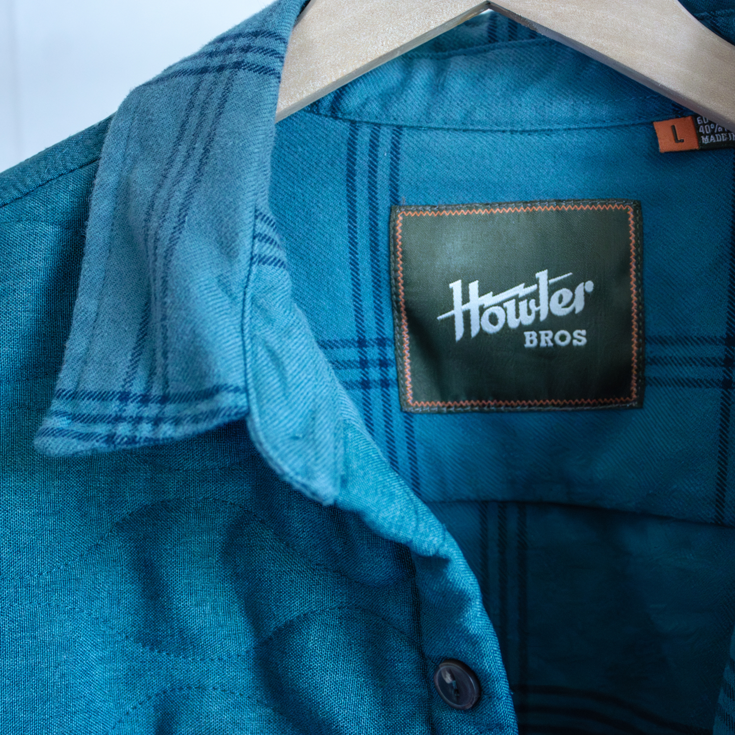 Blue shirt with a 'Howler Bros' label on a hanger