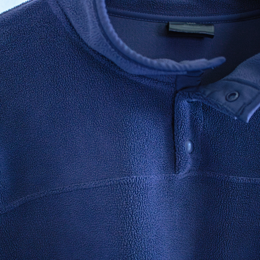 Close-up of a blue fleece jacket with a button